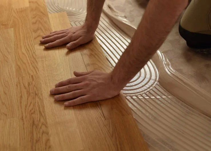Handgriffe bei der Arbeit an einem Holzboden.